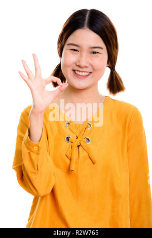 Studio shot of young happy Asian woman smiling tout en s ok Banque D'Images