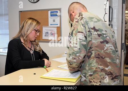 FORT BLISS, Texas - Esperanza Navarro, CONUS (contigus des États-Unis) la démobilisation greffier pour Tatitlek Corporation, aide un soldat à remplir les formalités administratives au cours de mobilisation/unité de démobilisation dans les actions du personnel du bureau (S1) Section de la mobilisation et le déploiement de la Brigade, Direction des plans, de la formation, la mobilisation et la sécurité à Fort Bliss, au Texas, le 31 octobre 2018. Les actions du personnel du bureau (S1) section est responsable de la gestion des documents essentiels pour la garde nationale, réserver et CONUS Centre de remplacement les soldats avant leur déploiement ou retour à l'accueil stat Banque D'Images