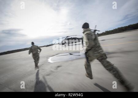 Les soldats de l'équipage d'air de l'armée américaine avec le New Jersey le détachement de la Garde Nationale 2, la Compagnie Charlie, 1-171st Soutien général Aviation Battalion courir vers leurs hélicoptères après une alerte d'urgence au cours de l'évacuation médicale de la formation sur une base commune McGuire-Dix-Lakehurst, N.J., le 14 novembre 2018. Banque D'Images