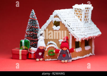 Maison avec des poupées Cookie arbre de Noël sur fond rouge Banque D'Images