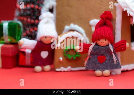 Maison avec des poupées Cookie arbre de Noël sur fond rouge Banque D'Images