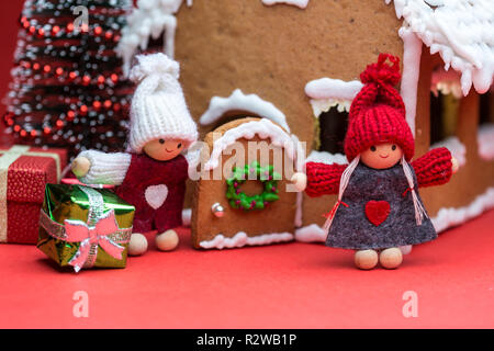 Maison avec des poupées Cookie arbre de Noël sur fond rouge Banque D'Images