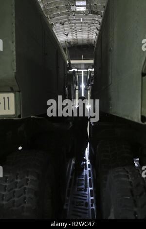 Un aviateur de la 62e Escadre de transport aérien se déplace entre les deux M-142 de l'Armée de haute mobilité système fusée lors d'un C-17 Globemaster, Novembre 15, 2018, at Joint Base Lewis-McChord, dans l'état de la mission a été le premier à l'infiltration d'air rapide HIMARS sur terre le nouveau centre de formation de la Yakima landing strip, Selah d'atterrissage, et une partie de sa cérémonie d'ouverture. Le paquet est un HIRAIN HIMARS, qui se compose de deux HIMARS et un centre directionnel Feux, qui est placé sur un C-17 Globemaster et utilisée comme une force de réaction rapide dans la défense américaine et les troupes alliées. Banque D'Images