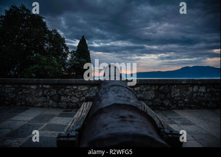 Vieux canon en fonte avec vue sur mer à partir de mur de château avec le coucher du soleil et des couleurs intenses, Trsat Croatie. Banque D'Images