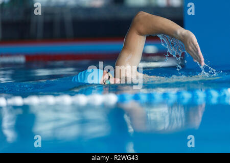 Photo de jeune athlète à capuchon bleu swimming in pool lors de l'entraînement Banque D'Images