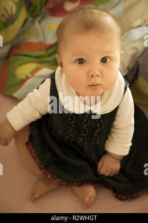 Cute baby girl sitting in a Bed Banque D'Images