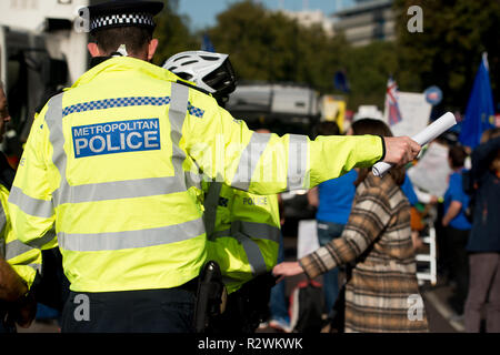 Agent de police métropolitaine traitant des demandes de protestataires, à un Brexit manifestation de protestation dans le centre de Londres, au Royaume-Uni. Banque D'Images