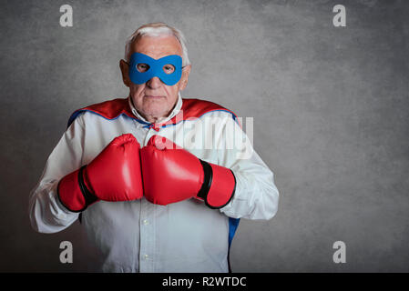 Man avec des gants de boxe sur fond gris Banque D'Images