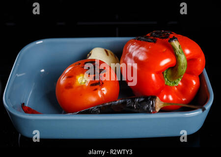 Légumes grillés, prêt à être pealed, dans un bol bleu Banque D'Images