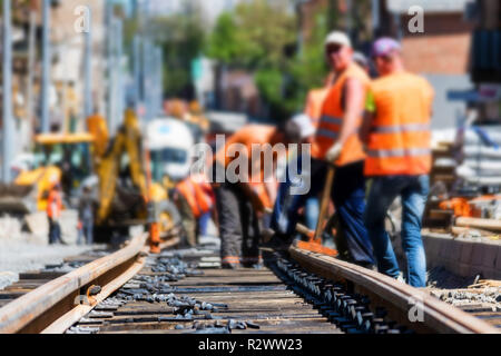 Les travailleurs des chemins de fer ou des uniformes brillants jeter voies de tram Banque D'Images