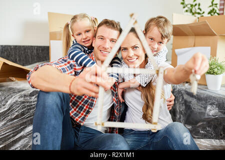 Famille et enfants avec règle de pliage en forme de maison comme un symbole de leur maison de rêve Banque D'Images