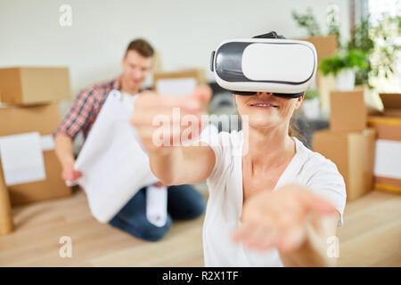 Jeune femme utilise des lunettes de réalité virtuelle dans le nouvel appartement à la planification de l'espace Banque D'Images