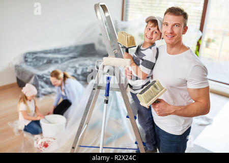 Famille et enfants tandis que la rénovation de peinture dans leur nouvelle maison Banque D'Images