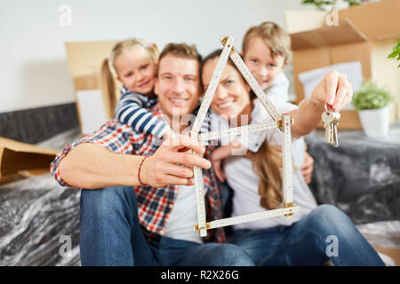 Famille avec règle de pliage en forme de maison ou bâtiment symbolisant la maison achat maison Banque D'Images