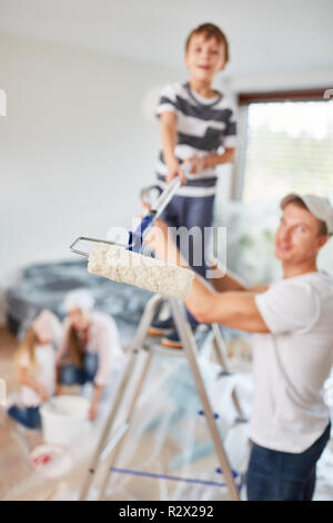 Famille et enfants dans la nouvelle maison alors que la rénovation de peinture Banque D'Images