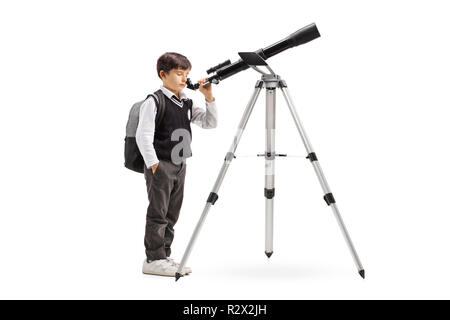 Tourné sur toute la longueur d'un écolier en uniforme à la recherche à travers un télescope isolé sur fond blanc Banque D'Images