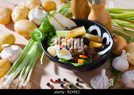 Salade saine avec des coeurs de poulet, des tranches de pêches, poires et fromage frit décorées avec des verts et des oeufs de cailles servi dans une poêle Banque D'Images