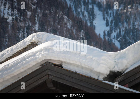 Beaucoup de neige en couches sur le toit de maisons d'habitation sur un après-midi ensoleillé Banque D'Images