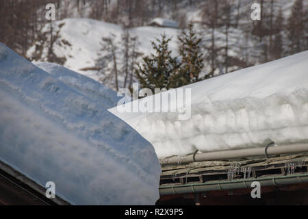 Beaucoup de neige en couches sur le toit de maisons d'habitation sur un après-midi ensoleillé Banque D'Images