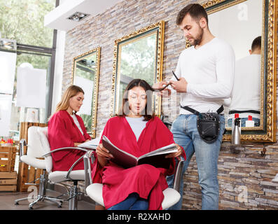 Guy positif coiffure cheveux des femmes en collaboration avec le salon de coiffure Banque D'Images