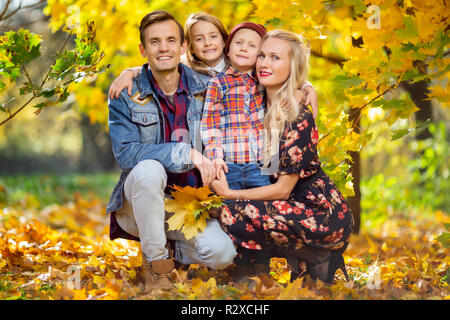 Photo de famille heureuse avec des enfants sur le parc promenade en automne Banque D'Images