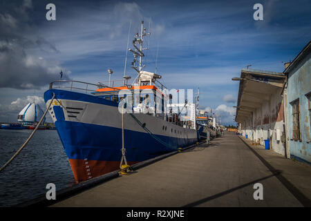 Bleu, rouge et blanc peint en bateau de pêche ancré par la jetée sur la péninsule de Hel, Pologne Banque D'Images