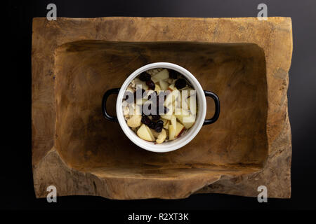 Le petit-déjeuner sur un bol rectangulaire en bois noir et blanc avec un pot. Banque D'Images