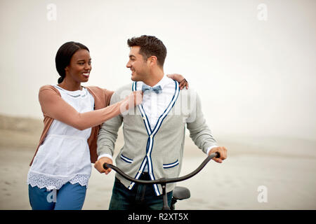 Happy young couple standing on a beach. Banque D'Images