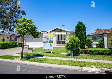 Maison australienne typique étant commercialisée pour la vente à Parklea, Sydney, NSW, Australie avec signe d'agent immobilier érigé Banque D'Images