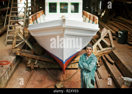 Portrait of a middle aged man standing in front of an incomplete bateau. Banque D'Images