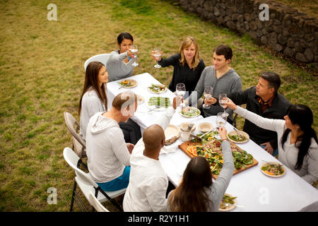 Mid adult man réchauffe avec s'étend avant d'exercer dans le parc. Banque D'Images