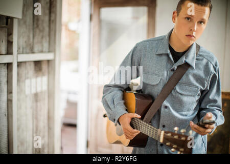 Jeune homme de prendre pause de jouer de la guitare. Banque D'Images