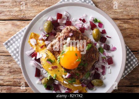 Tartare de boeuf frites ou Steak Parisien - Pariserbof avec des œufs, des légumes et de la moutarde gros plan sur une assiette sur la table. Haut horizontale Vue de dessus Banque D'Images