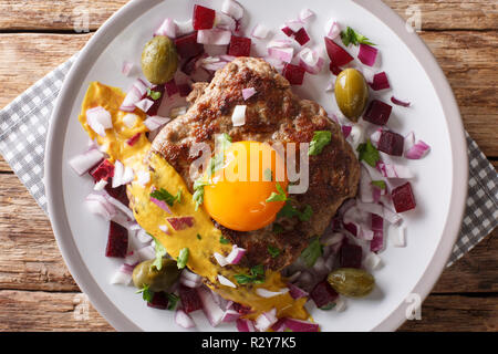 Une cuisine danoise : steak ou Pariserbof parisien avec des légumes et la moutarde gros plan sur une assiette sur la table. Haut horizontale Vue de dessus Banque D'Images