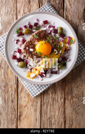 Pariserbof danois délicieux servi avec des matières d'œuf, la moutarde et les légumes sur une assiette sur la table. Haut Vertical Vue de dessus Banque D'Images