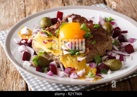 Steak danois traditionnel avec Pariserbof d'œuf et la moutarde, servi avec des oignons, des câpres et de la betterave close up sur une plaque sur la table horizontale. Banque D'Images