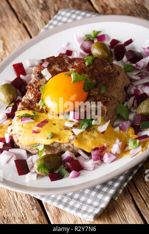 Une cuisine danoise : steak ou Pariserbof parisien avec des légumes et la moutarde gros plan sur une plaque verticale sur la table. Banque D'Images