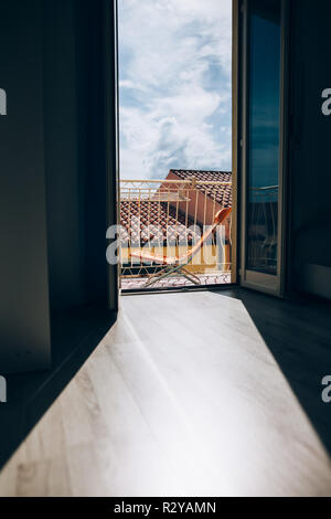 Fenêtre ouverte avec vue sur les toits de la ville en Italie. Ombre et Lumière dans la chambre. Billet et vous détendre concept Banque D'Images