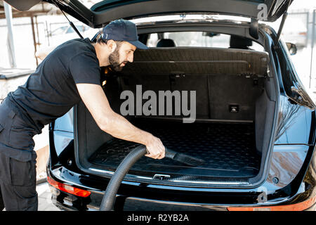 Nettoyeur Professionnel En T Shirt Noir Et Le Capuchon De L Aspirateur Coffre D Une Grosse Voiture De Luxe En Plein Air Photo Stock Alamy