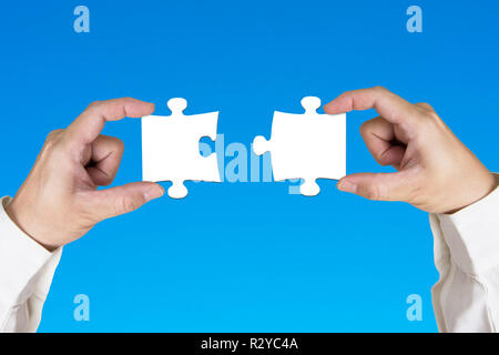 Montage de deux puzzles en blanc sur fond bleu Banque D'Images
