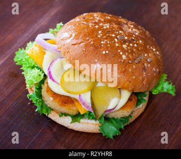 Pépites de poulet croustillant burger au fromage, concombres, oignons et feuilles de laitue Banque D'Images