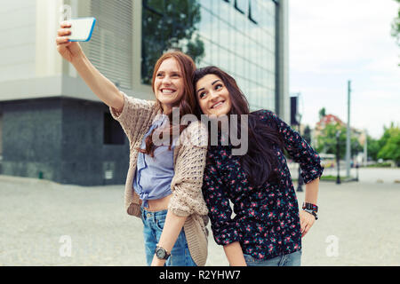 Jolies filles mignonnes selfies making funny dans la rue, de s'amuser ensemble, de joie, de bonheur, d'amour, d'amitié, de soeurs. Banque D'Images