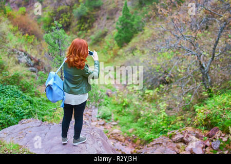 Amazing touriste avec un sac à dos voyages dans les montagnes au printemps. Très joli female hiker enregistrer une vidéo vlog pour son avancement dans les montagnes de canal Banque D'Images