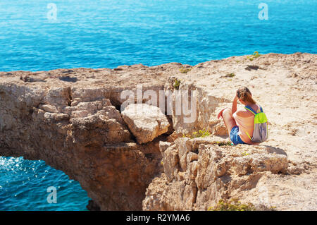 Un caucasian girl situées au bord de la falaise, appuyé contre sa main avec son dos se détourna, regardant dans la distance, penser, sentir t Banque D'Images