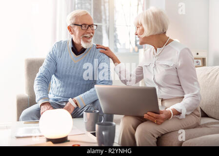 Couple grisonnant discuter énergiquement les marchandises doivent être achetés en ligne Banque D'Images