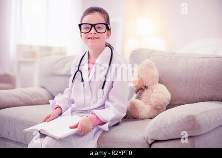 Jeune fille portant des lunettes et veste blanche ayant le désir de devenir un médecin Banque D'Images