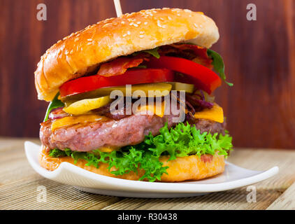 Double cheeseburger appétissant avec deux galettes de boeuf grillé et bacon Banque D'Images