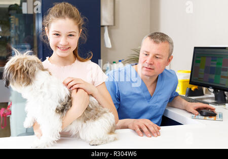 Portrait of happy girl avec son chien par consultation vétérinaire professionnel Banque D'Images