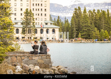 LAKE LOUISE, ALBERTA, CANADA - Juin 2018 : Les Amis de prendre une photo selfies sur un téléphone mobile lors d'une visite à Lake Louise en Alberta, Canada. Dans le backgroun Banque D'Images