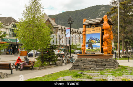 BANFF, ALBERTA, CANADA - Juin 2018 : grand panneau pour le parc national Banff à l'extérieur du centre d'information touristique avec la sculpture sur bois dans le centre-ville de Banff. Banque D'Images